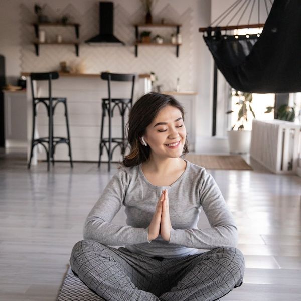 Cozy corner for home yoga practice with a mat, candles, and a plant.