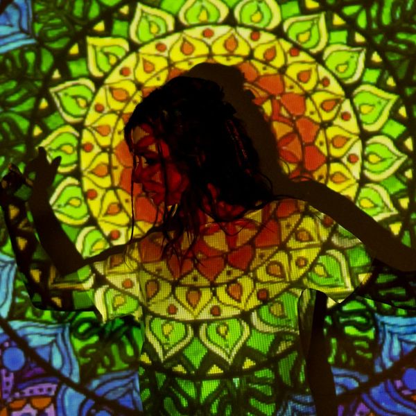 Woman meditating in a lotus pose against a dark background with flowing energy lines.